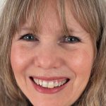 Smiling woman with blonde hair and blue eyes close-up portrait