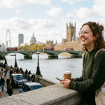 Smiling woman in London holding coffee with iconic cityscape including Big Ben and the London Eye in the background