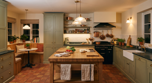 Cosy kitchen with wooden island, vegetables, copper pans, and a breakfast nook with plants and natural lighting